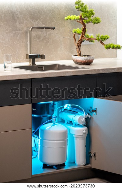 House\
water filtration system. Osmosis deionization system. Installation\
of water purification filters under kitchen\
sink