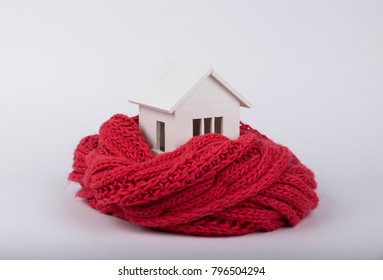 House In Winter - Heating System Concept And Cold Snowy Weather With Model Of A House Wearing A Knitted Cap