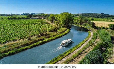 Houseboat in Canal du Midi aerial drone view from above, family water travel by boat, vacation in Southern France