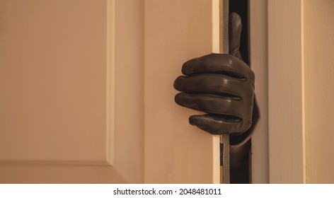 Housebreaking, Burglary Concept. Gloved Hand Opening The Entrance Door, Burglar Entering Illegally The House