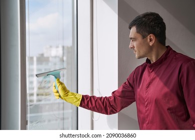 Housecleaner Cleaning Glass Surface Using Tool With Rubber Blade