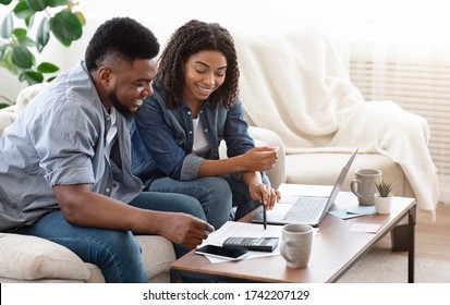 Household Budget. Smiling Black Couple Discussing Total Amount Of Their Spends At Home, Happy About Wise Planning