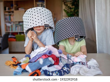 Hausarbeit für Kinder. Kinder, die ihr Zimmer putzen, trockene Socken sortieren und sie mit Spaß in persönliche Körbe gestalten, machen das Reinigen zum Spiel. Alltägliche Routine, Lebensstil