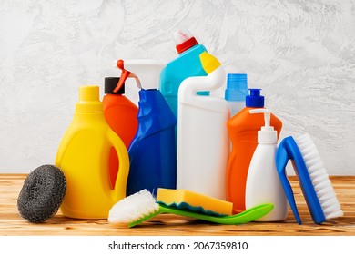 Household cleaning detergents on wooden table against gray background - Shutterstock ID 2067359810