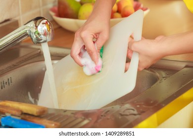 Household. Closeup Woman Doing The Washing Up In Kitchen Cleaning Plastic Cutting Board