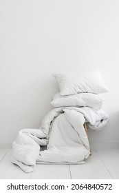 Household, hotel service and laundry concept. Vertical view of clean white blanket and two pillows on chair against copy space background wall in bright bedroom. Stack bedding for sleep - Shutterstock ID 2064840572