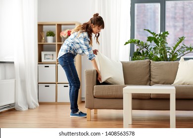 Household, Housework And Cleaning Concept - Asian Woman Arranging Sofa Cushions At Home