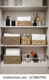 Household items, toilet paper rolls, white bath towels and cosmetics bottles on shelves in the bathroom cabinet Organization of space in wardrobe. Bedding, linen, home perfumes and folded bathrobes - Shutterstock ID 2178807905