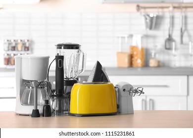 Household and kitchen appliances on table against blurred background - Shutterstock ID 1115231861