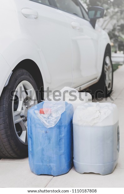 Household\
storage of gasoline in gallons for a possible lack of fuel.\
Gasoline in gallons next to a car, preventive act. Plastic bag in\
the lid to not leak or evaporate\
gasoline.