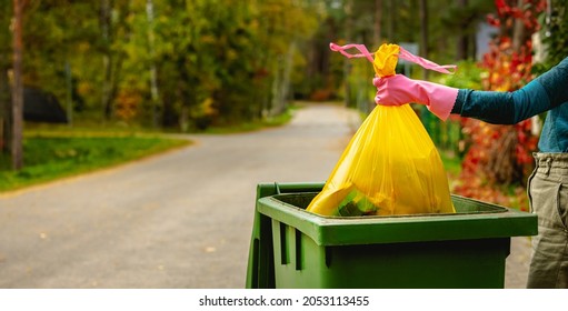 Household Waste - Hand Insert Yellow Plastic Unsorted Garbage Bag Into Trash Bin On The Street. Copy Space