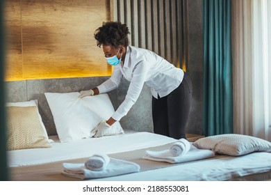 Housekeeper Or Maid Cleaning Hotel Room. African Woman Worker Working In Hotel And Resort. People Wearing Protective Face Mask Prevent Covid-19 Virus