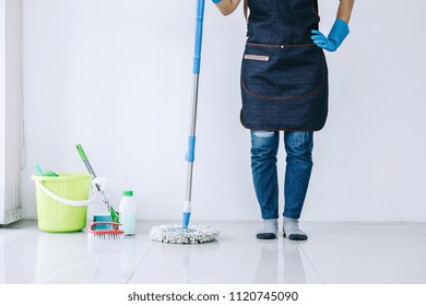 Housekeeping And Cleaning Concept, Happy Young Woman In Blue Rubber Gloves Wiping Dust Using Mop While Cleaning On Floor At Home.