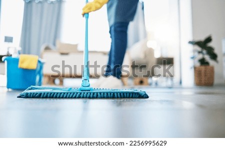 Housekeeping, cleaning and woman maid with a mop to clean the living room floor at a house. Female domestic worker, cleaner and housewife washing the ground for bacteria, dust or dirt in her home.