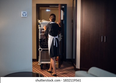 A housekeeping lady in a uniform doing room service in a hotel. - Shutterstock ID 1832119561