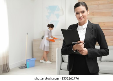 Housekeeping Manager Checking Maid Work In Hotel Room