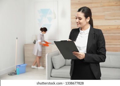 Housekeeping Manager Checking Maid Work In Hotel Room