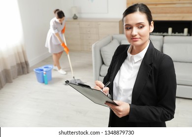 Housekeeping Manager Checking Maid Work In Hotel Room