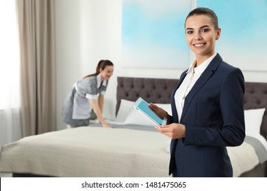 Housekeeping Manager With Tablet Checking Maid Work In Hotel Room. Space For Text