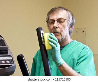 Housekeeping Worker Cleaning And Disinfecting Some Exercise Equipment