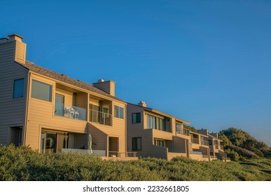 Houses with balconies against blue sky at scenic Del Mar Southern Califronia. Facade of beach homes on a quiet seaside neighborhood on a beautiful sunny day.