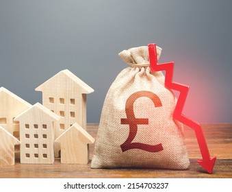 Houses And British Pound Sterling Money Bag With Down Arrow. Reducing Maintaining Cost, Energy Efficiency. Falling Of Real Estate Market Prices. Realty Crisis. Low Rates On Mortgages. Taxes. Budget.