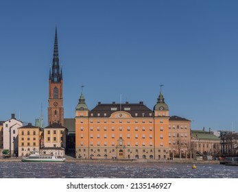 Houses And Church In The Island Riddarholmen At The Bay Riddarfjärden With Ice Floes A Sunny Winter Day In Stockholm, Swede, 2022-03-06