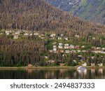 Houses and condominiums on a mountain foothill in West Juneau on Douglas Island, with a view of Gastineau Channel across from downtown Juneau, on a sunny morning in mid June, southeast Alaska