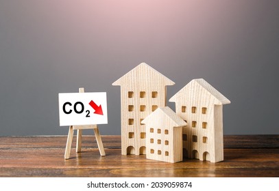 Houses and easel with carbon dioxide reduction. Environmentally friendly. Improving utilities and energy efficiency. Impact on environment. Reduced greenhouse gas emissions, low carbon footprint.