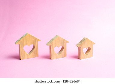 Houses With Hearts Inside On A Pink Background. The Concept Of Finding A Love Nest. Affordable Housing For Young Families And Couples. Rental Of Houses And Apartments By Young People. Valentine's Day.