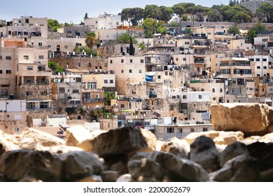 Houses of an old arabian village in Jerusalem, Israel with blurred stones on the foreground. View from City of David