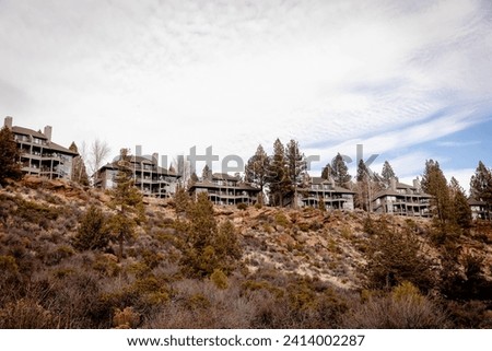 Houses on rocky slopes along Deschutes River Trail South Canyon Reach in Bend, Oregon. A popular hiking and running trail along a river in Bend, a town in Cascade Mountains