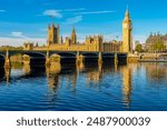 Houses of parliament with Big Ben tower and Westminster bridge reflected in Thames river, London, UK