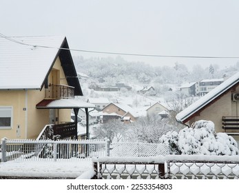 houses and trees and fences under white snow - village Milanovac at winter, Croatia - Shutterstock ID 2253354803
