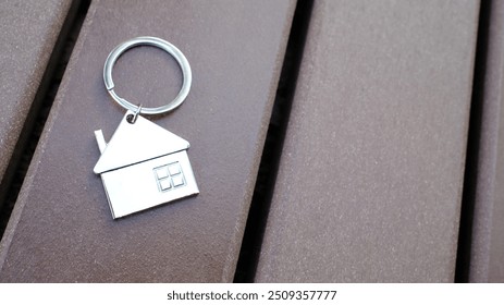 house-shaped keychain against wooden surface. Real estate, property ownership, new home concept. - Powered by Shutterstock