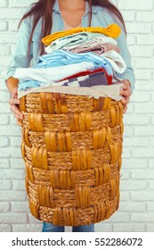 Housewife Bringing A Huge Pile Of Laundry On The Ironing Board