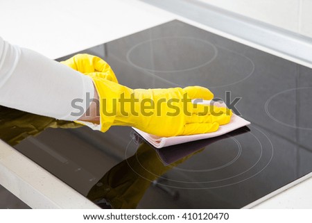 Housewife cleaning an induction plate, closeup shot