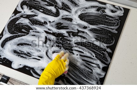 Housewife cleaning an induction plate, closeup shot
