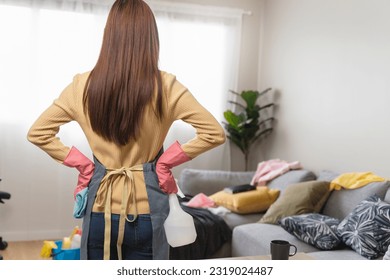 Housewife cleaning mess stuff in living room