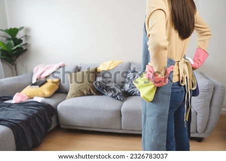 Housewife cleaning mess stuff in living room
