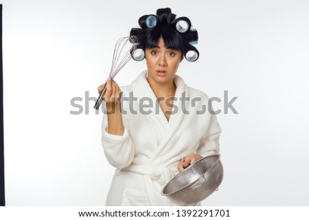   housewife with curlers whisk colander on white background                             
