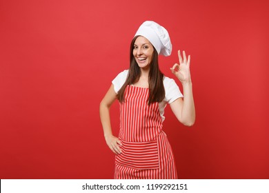 Housewife female chef cook or baker in striped apron, white t-shirt, toque chefs hat isolated on red wall background. Beautiful pensive housekeeper woman making okay sign. Mock up copy space concept - Powered by Shutterstock