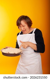 Housewife With Homemade Cakes On A Colored Background.
Shot Of Joyful Positive Mature Woman Enjoying Birthday Party Eating Apple Pie. Senior Woman Posing With Dessert. Celebration, Food And Dessert.