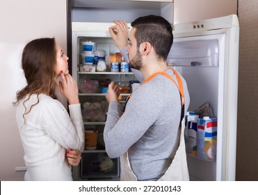 Housewife Showing Broken Refrigerator To Serious Repairman