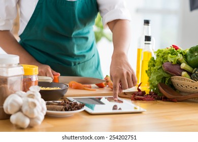 Housewife using tablet computer to cook in the kitchen, selective focus - Shutterstock ID 254202751