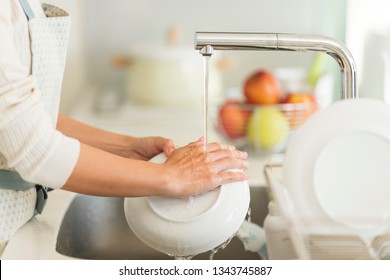 Housewife Washing Dishes In The Kitchen Sink