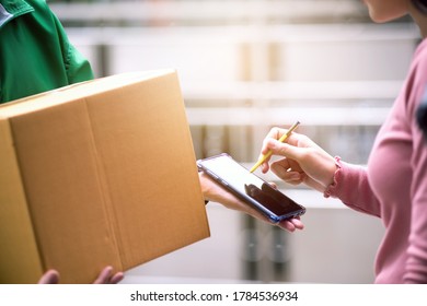 Housewife woman sign a package from a sender on a smartphone in the digital age, responding to the world of technology without borders. - Shutterstock ID 1784536934