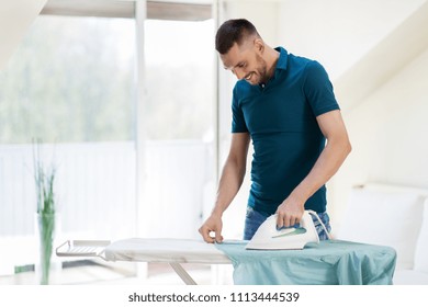 housework and household concept - man ironing shirt on iron board at home - Powered by Shutterstock