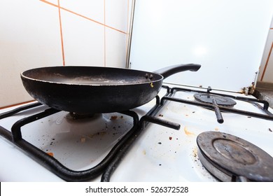 Housework, hygiene and cleaning concept. Dirt at home. Dirty filthy gas stove with used kitchen cooking stuff, frying pan - Shutterstock ID 526372528