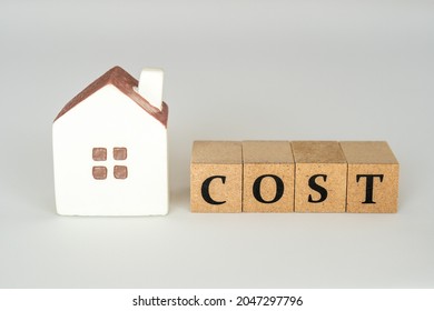 Housing cost concept (miniature house and the word COST)